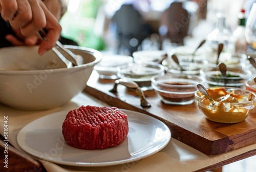 Fotografie Closeup shot of chef making steak tartare on trolley with spices and ingredients