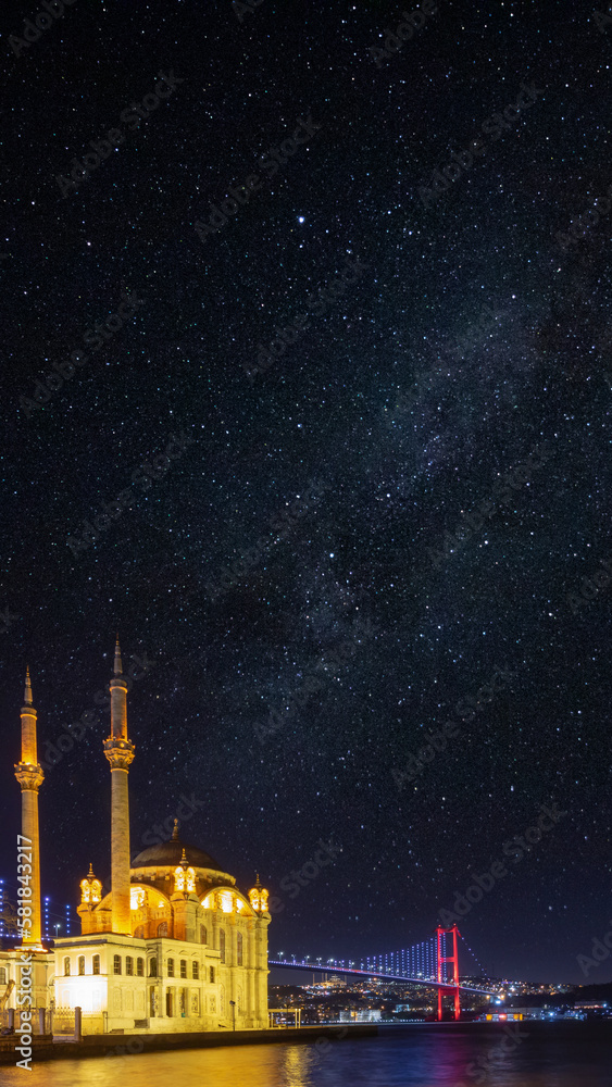 Fototapeta premium Islamic vertical bakground photo. Ortakoy Mosque and Bosphorus Bridge