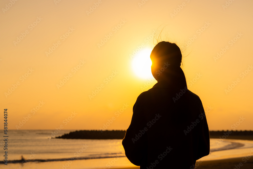 Silhouette of woman enjoy the sunset in the beach