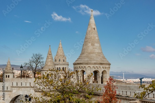 Scenic view of the Fisherman s bastion with conical roofs and autumn trees outside against blue sky