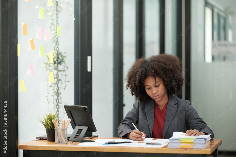 American African Woman working in the office with computer phone and Tablet. American African Woman working in the office with computer phone and Tablet.