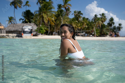 Beautiful tan Colombian women in crystal Caribbean sea water in San Blas Palm tree Islands, Panama © Calum