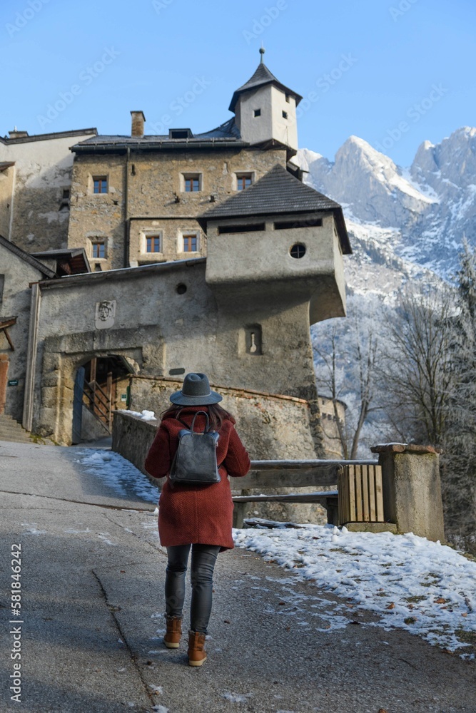 Woman walking up the road to Hohenwerfen castle and fortress at Werfen in Austria