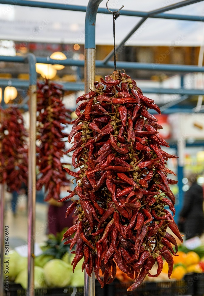 Vertical closeup shot of a string with dried red peppers on them in a market