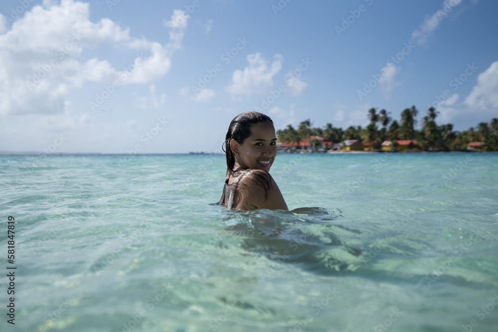 Beautiful tan Colombian women in crystal water on Caribbean island in San Blas