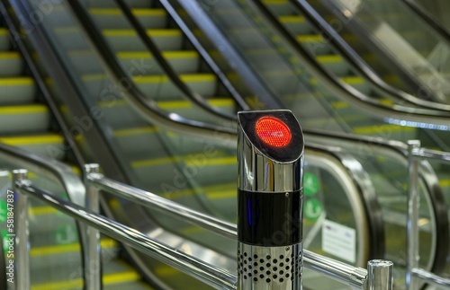Closeup of a red signal light in front of the escalator with blurred background © Marko Klarić/Wirestock Creators
