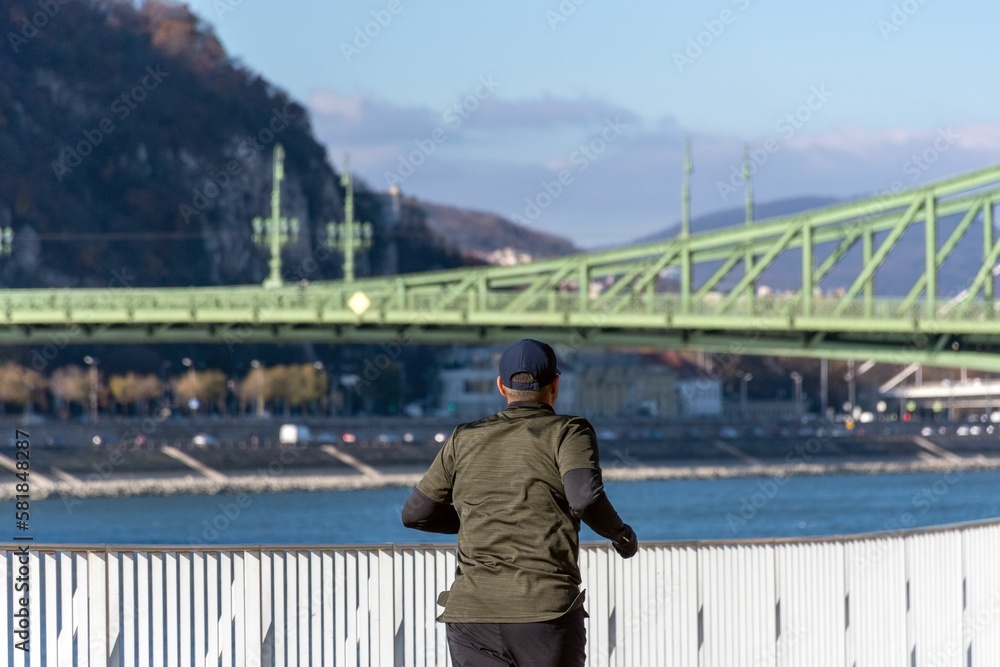 Man jogging on promenade by Danube river in Budapest, Hungary