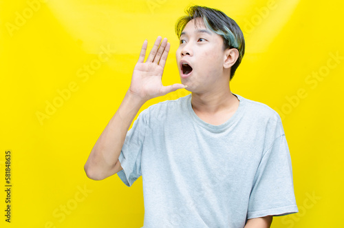 portrait of Young asian man open arms, hands and point finger to present something. proud Asian man with a smile offers, presents and advertise an advertisement 
