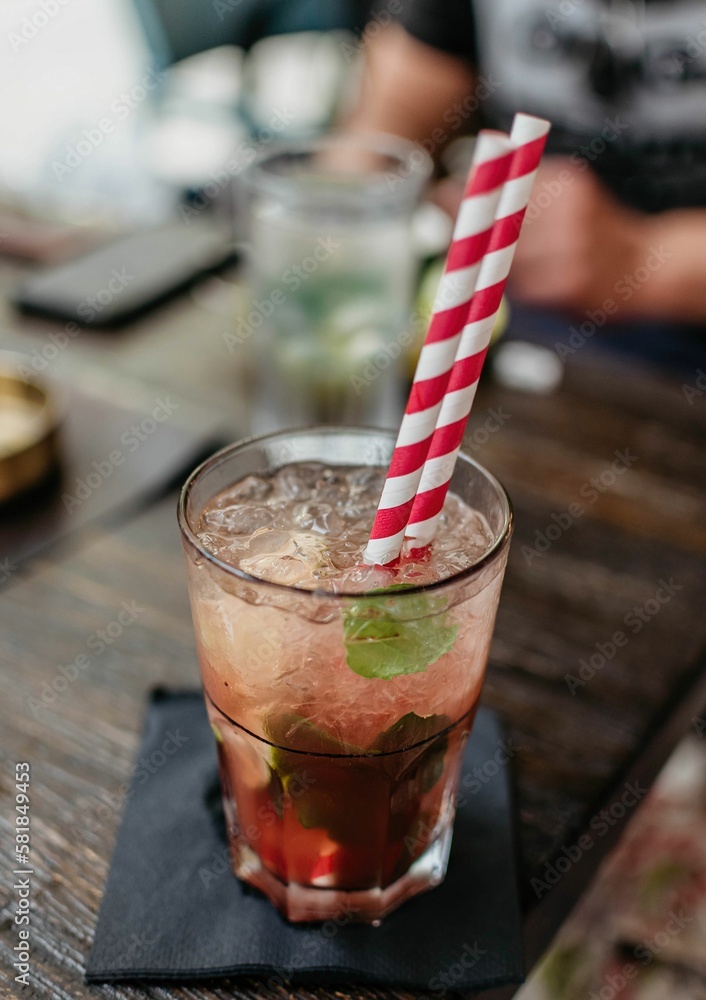 Cocktail with ice, mint, and striped straws Cocktail with ice, mint, and striped straws