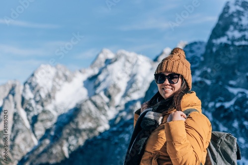 Closeup of a happy woman standing in front of mountain peaks in Julian alps in Slovenia