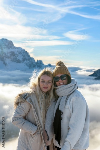 View of Caucasian women wearing warm cloth and standing in front of snow covered mountain