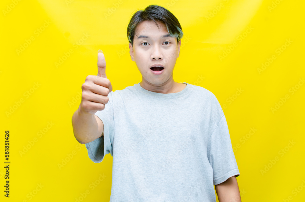 estactic attractive funky young asian man shocked happily opening mouth and raising his hand. asian man in gray tshirt feels shock with wow surprised expression.
estactic attractive funky young asian man shocked happily opening mouth and raising his hand. asian man in gray tshirt feels shock with wow surprised expression.