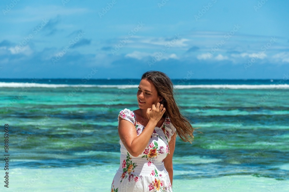 Portrait of beautiful happy woman posing on beach with amazing turquoise ocean in the back Portrait of beautiful happy woman posing on beach with amazing turquoise ocean in the back