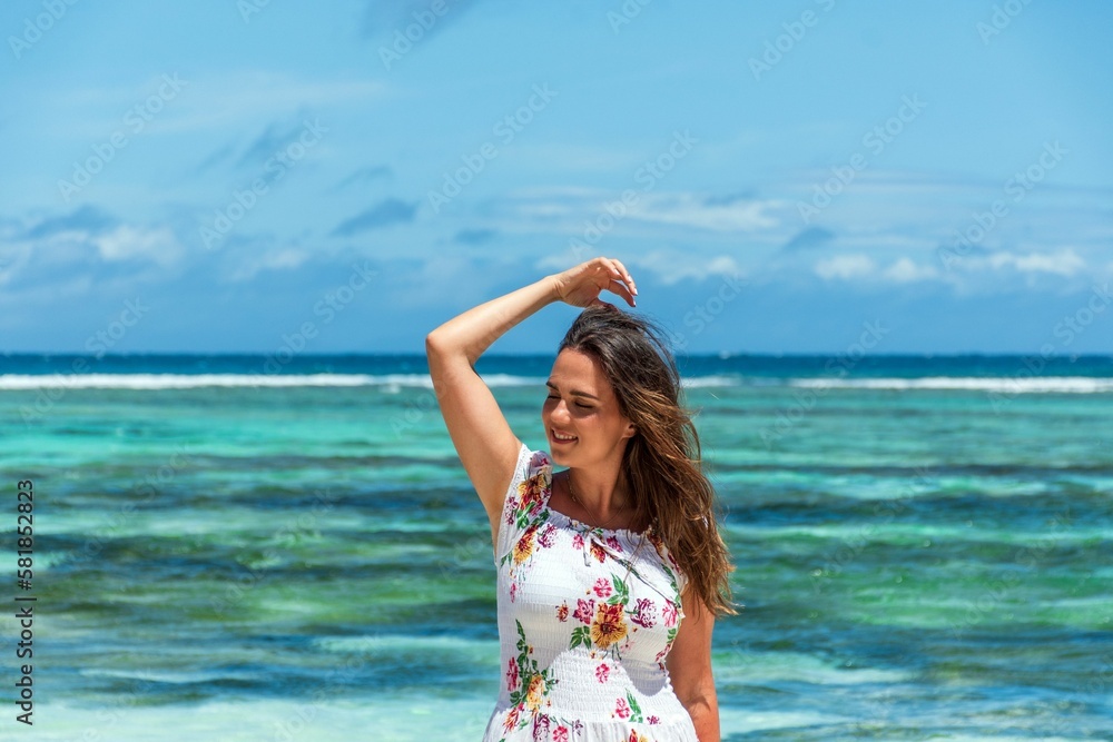 Portrait of beautiful happy woman posing on beach with amazing turquoise ocean in the back Portrait of beautiful happy woman posing on beach with amazing turquoise ocean in the back