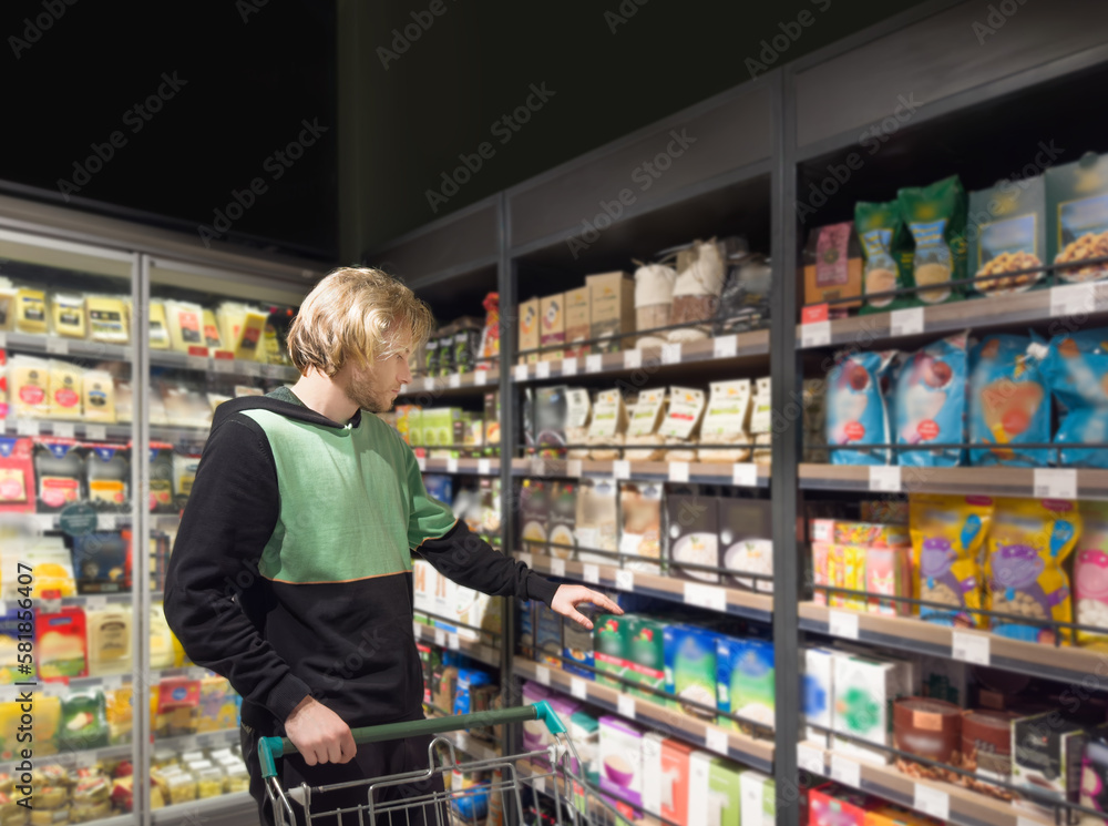 Man choosing frozen food from a supermarket freezer., reading product information