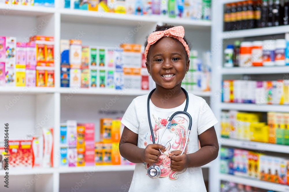 Portrait of Black African girl Child in a pharmacy with stethoscope, dreams to become doctor in future.
