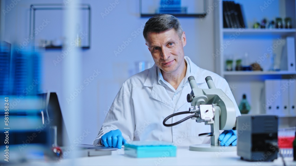 Confident man laboratory worker smiling on camera, scientist conducting research