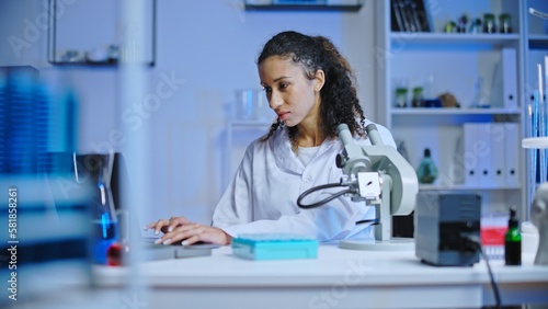 Focused woman laboratory technician working on computer, doing scientific research