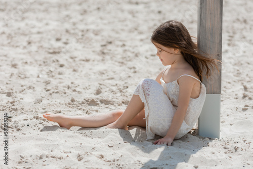 happy little girls play on a white sandy beach near the ocean in summer. Children s holidays. Earth Day. Children s Day.Space for text