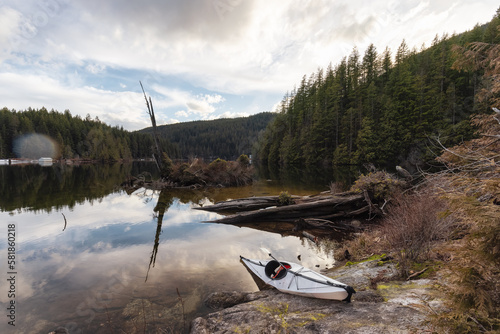 Kayaking in calm water with Canadian Mountain Landscape Background. Buntzen Lake in Vancouver, British Columbia, Canada. photo