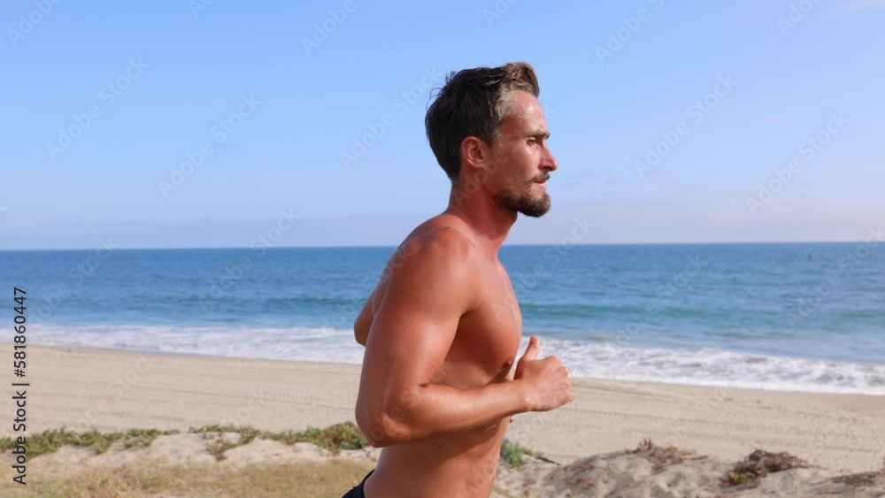 Athletic man jogging at the beach in Southern California. Slow Motion. Athletic man jogging at the beach in Southern California. Slow Motion.