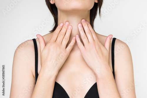Canvas Print a woman holds her throat with her hand because of problems with her throat and t