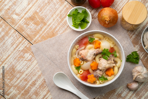 Macaroni Soup with drumette chicken ,tomato ,carrots and onion ,easy asian style clear soup in white bowl