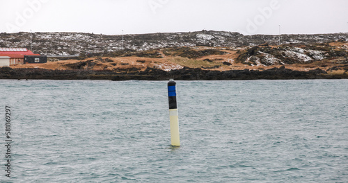 Black yellow spar buoy with light on top. Navigation equipment
