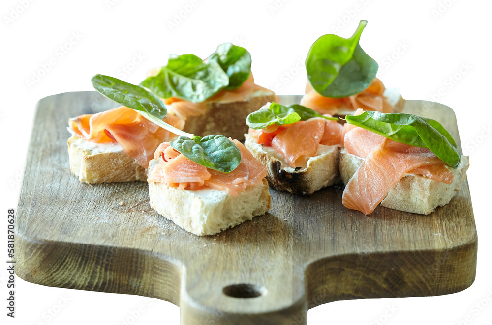 Selection of tasty bruschetta or canapes with salmon closeup. Isolated on a wooden board Selection of tasty bruschetta or canapes with salmon closeup. Isolated on a wooden board
