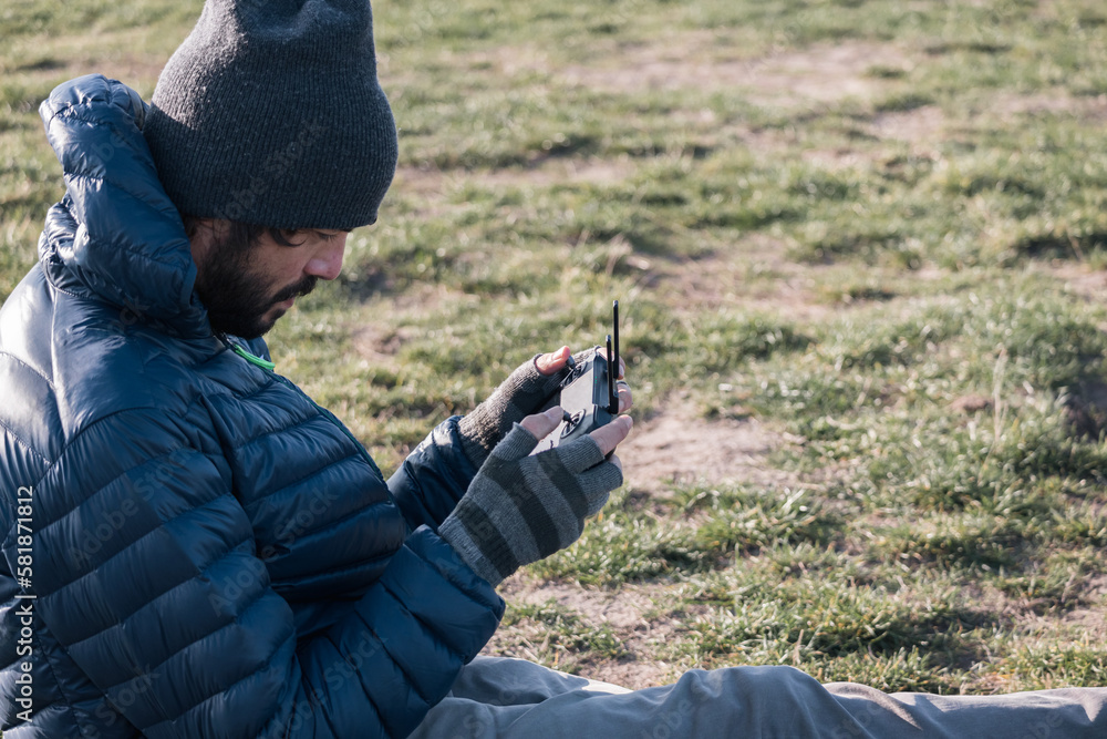 An unmanned aerial vehicle pilot controls the drone using a flight controller Stock Photo