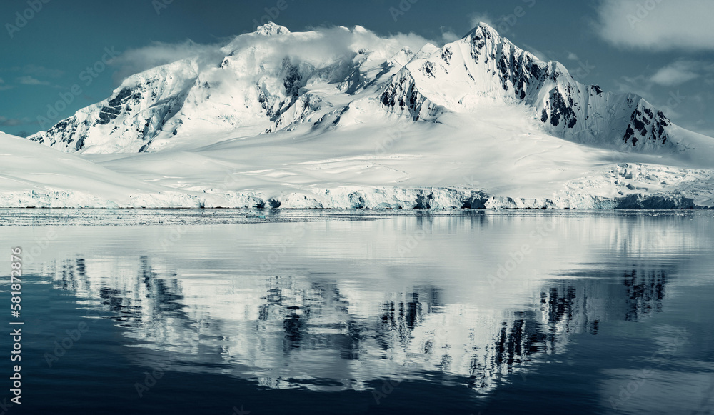 Panorama of Snow Glacier Covered Mountains Reflecting in the Still Arctic Water of Antarctica, Moody Image