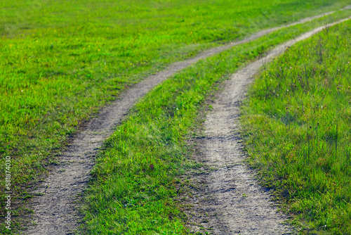 ground road among green fields, natural countryside transportation background