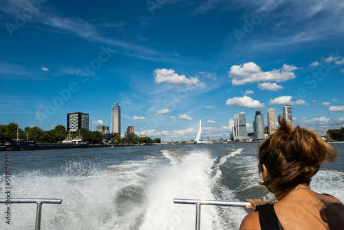 wake from Rotterdam Netherlands watertaxi vessel in high speed journey with female passenger. fast public transportation boat taxi service on water around Dutch city on sunny summer day in Holland