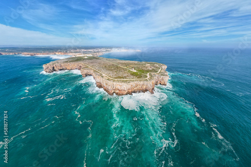Spectacular view of Sagres fortress peninsula with a lighthouse on the cliff surrounded by the Atlantic Ocean, Sagres, Algarve region, Portugal.