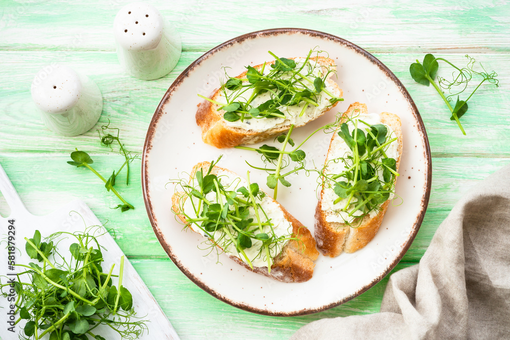 Open sandwich with cream cheese and micro greens at green background. Natural Healthy food, natural vitamins. Top view.