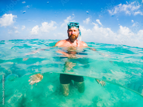 man snorkeling in crystal clear tropical sea