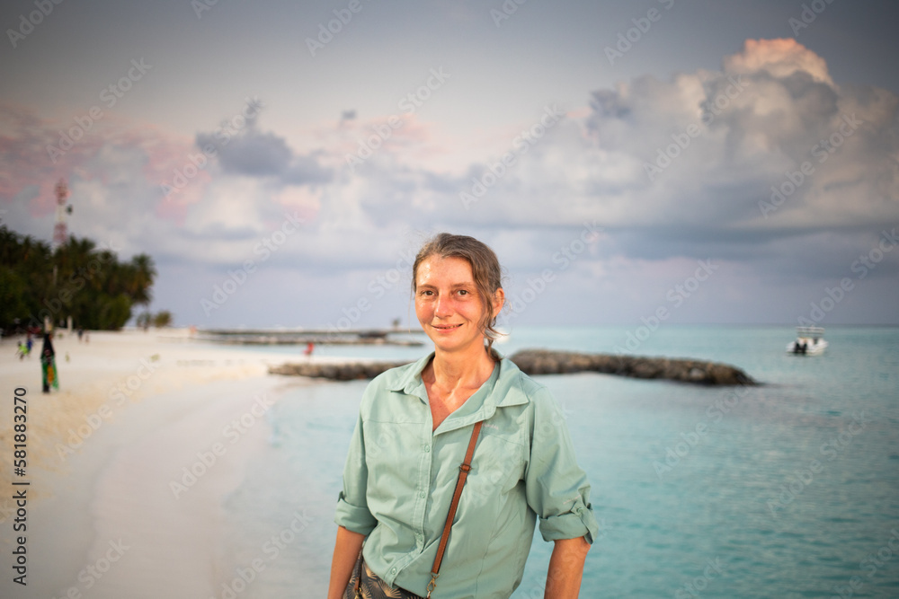 woman looking at pink sunset over tropical sea freedom