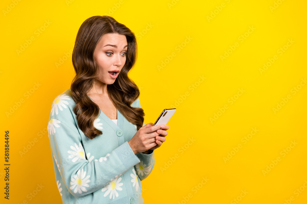 Photo of positive impressed woman wear turquoise cardigan communicating device empty space isolated yellow color background Photo of positive impressed woman wear turquoise cardigan communicating device empty space isolated yellow color background