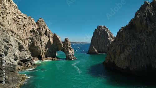 Aerial pan across El Arco Cabo San Lucas Arch, Los Cabos Mexico. Drone from above the water with early day light.