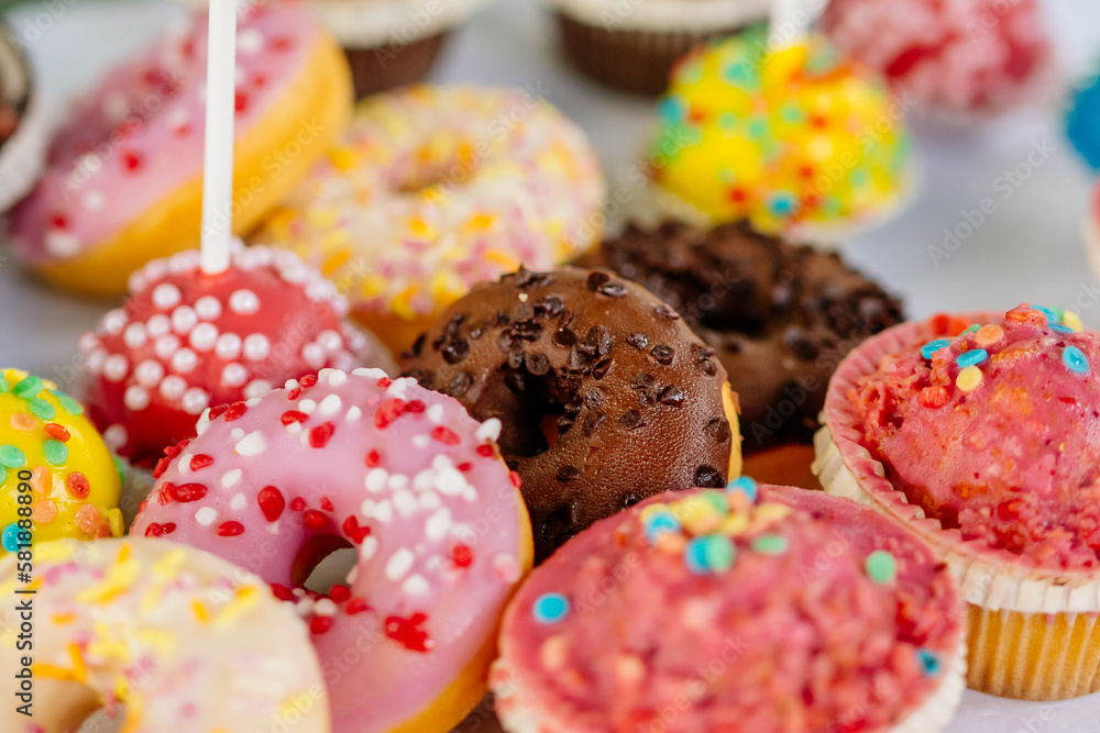 bunte Donuts, Muffins und Cakepops mit Streuseln auf Kuchenbuffet bei ...