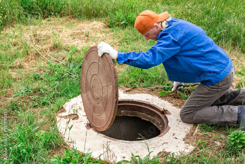 Quadro su tela the man opened the cover of the sewer manhole to pump out the sewage