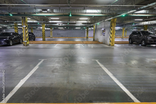 Lines for parking cars. Traffic background, a picture of a parking lot in a shopping center. Underground parking with parked cars, where there is a place to copy. High quality photo