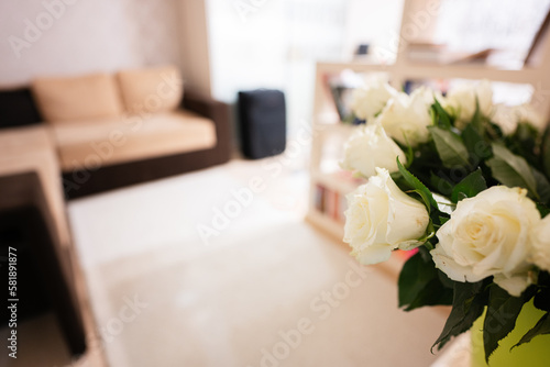 White roses flowers bouquet in green pot at home.