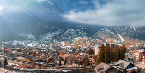 Aerial panorama of the Grindelwald  Switzerland village view near Swiss Alps mountains panorama landscape  wooden chalets on green fields and high peaks in background  Bernese Oberland  Europe.