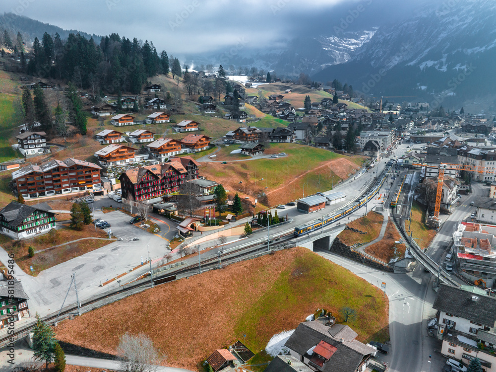 Aerial panorama of the Grindelwald, Switzerland village view near Swiss Alps mountains panorama landscape. Famous Train with Jungfrau Mountain on Sunny Day in Grindelwald