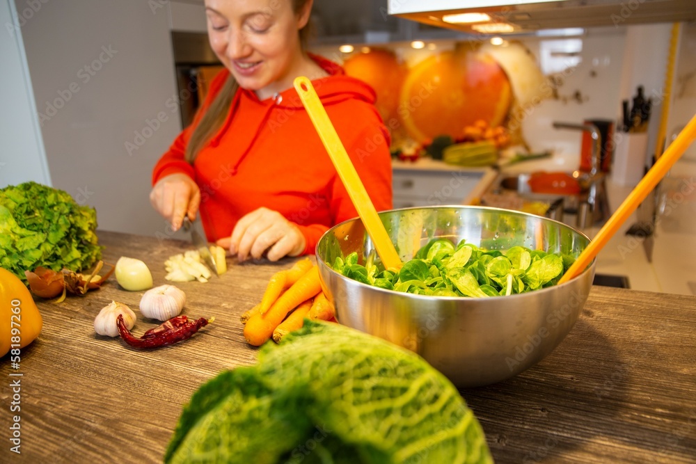 Vegan Kochen: Junge Frau bereitet Feldsalat zu - obrazy, fototapety, plakaty 