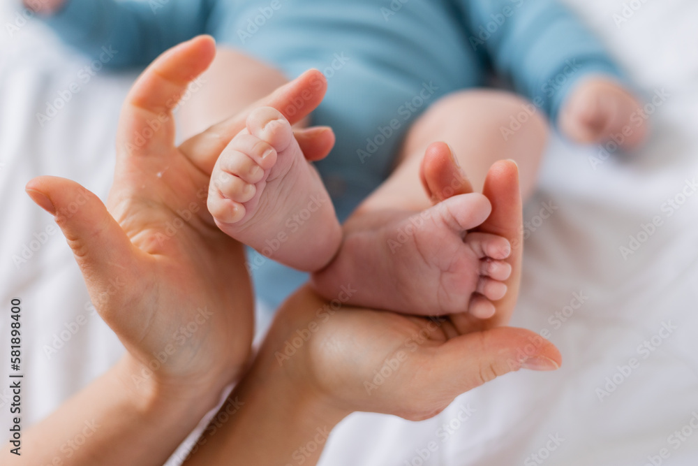 mom holds baby's small feet close-up mom holds baby's small feet close-up