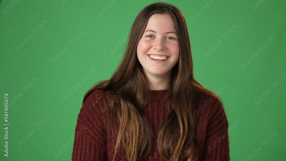 Fototapeta premium Portrait of young beautiful laughing casual female. Teen girl talking to friends family online, blogging, laughing on green screen. Camera point of view