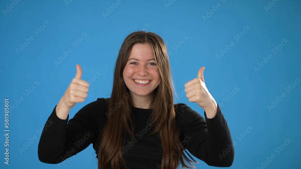 Shocked amazed say wow doing winner gesture put hands up young woman 20s posing isolated on blue background studio. People lifestyle concept. Shocked amazed say wow doing winner gesture put hands up young woman 20s posing isolated on blue background studio. People lifestyle concept.