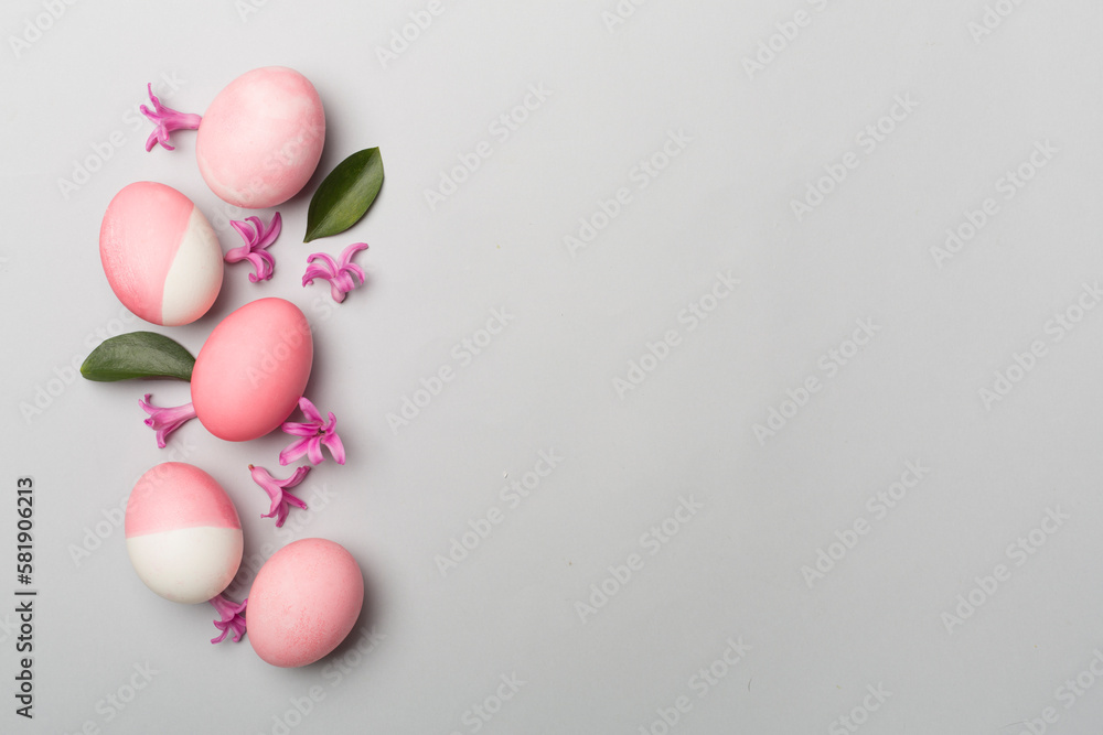 Pink Easter eggs with decor on color background, top view